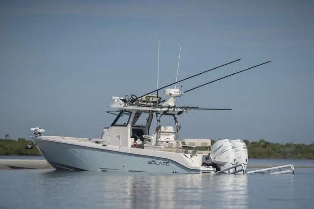 Slide: The Image of Manufacturer Provided Image: 2026 Solace 30 HCS boat on calm water, equipped with fishing rods and dual engines. - 2