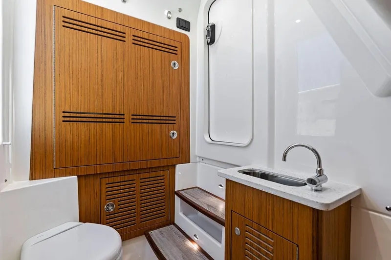 Slide: The Image of Manufacturer Provided Image: 2026 Solace 32 CS boat interior with wooden cabinetry, sink, and modern design. - 11