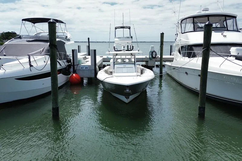 The Image of 2018 Everglades 435 Center Console docked between two yachts on a sunny day. - 0