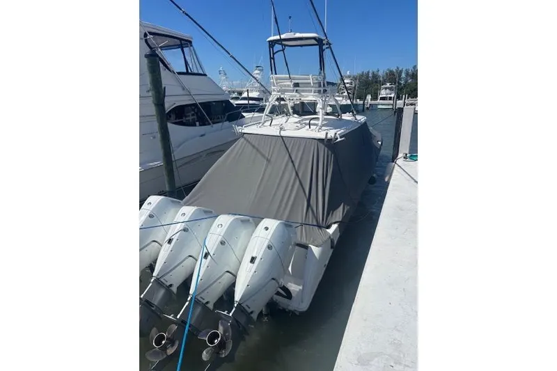 Slide: The Image of 2018 Everglades 435 Center Console boat docked with covered deck and multiple outboard engines. - 10