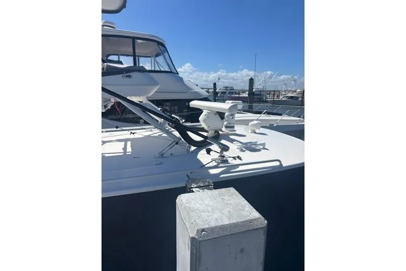 Slide: The Image of 2018 Everglades 435 Center Console boat docked under clear blue sky. - 12