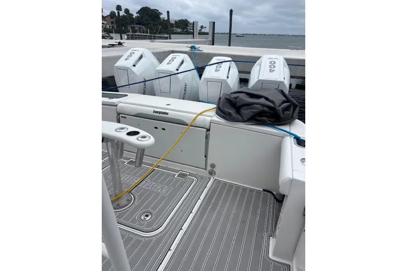 Slide: The Image of 2018 Everglades 435 Center Console boat with four outboard engines docked by the water. - 15