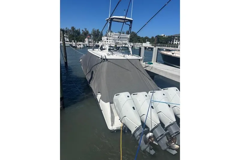 The Image of 2018 Everglades 435 Center Console boat docked with protective cover and multiple outboard engines. - 21