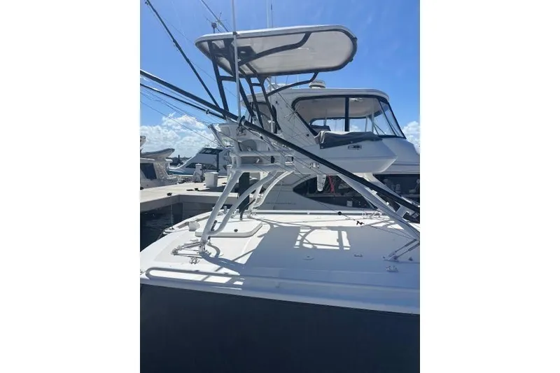 Slide: The Image of 2018 Everglades 435 Center Console boat docked under clear blue sky. - 25