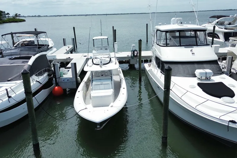 Slide: The Image of 2018 Everglades 435 Center Console boat docked among other vessels at a marina. - 3