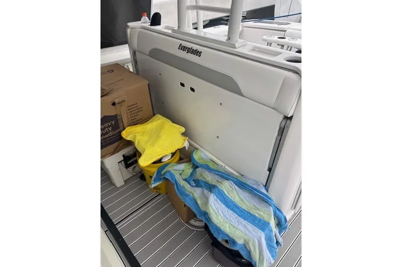 Slide: The Image of 2018 Everglades 435 Center Console boat interior with storage items and striped towel. - 33