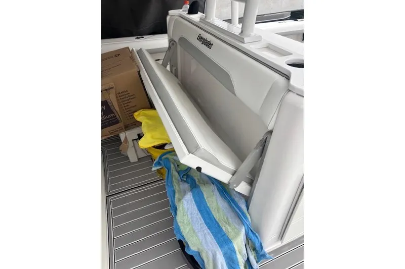Slide: The Image of 2018 Everglades 435 Center Console boat with open storage compartment and colorful towels. - 34