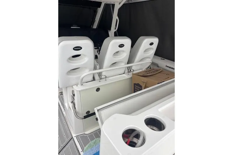 Slide: The Image of 2018 Everglades 435 Center Console boat interior with white seating and storage compartments. - 35