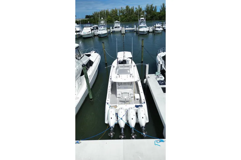 Slide: The Image of 2018 Everglades 435 Center Console boat docked at marina with multiple engines. - 4