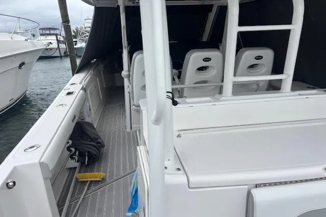 Slide: The Image of 2018 Everglades 435 Center Console boat docked, showcasing spacious seating and sleek design. - 45