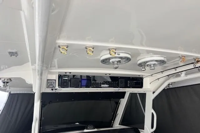 Slide: The Image of 2018 Everglades 435 Center Console boat interior with electronic controls and fishing rod holders. - 49