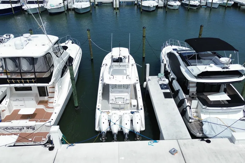 Slide: The Image of 2018 Everglades 435 Center Console docked between two yachts in a marina. - 5
