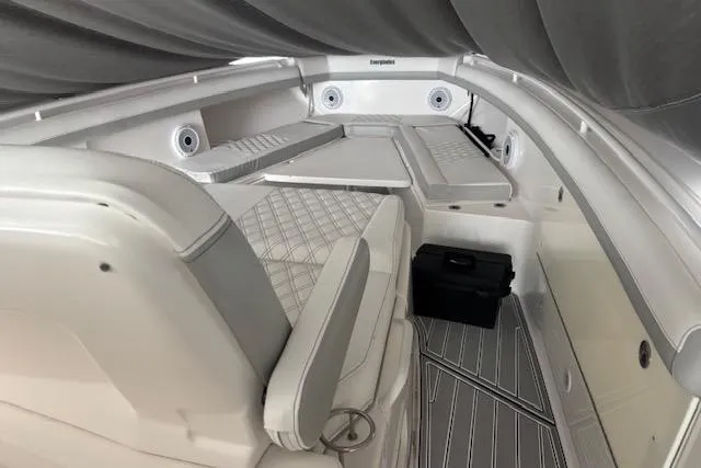 Slide: The Image of 2018 Everglades 435 Center Console boat interior with cushioned seating and storage compartments. - 56