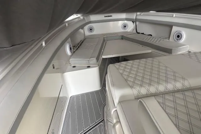 Slide: The Image of 2018 Everglades 435 Center Console boat interior with cushioned seating and table. - 58