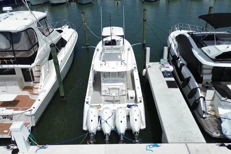 Slide: The Image of 2018 Everglades 435 Center Console boat docked between yachts in a marina. - 6
