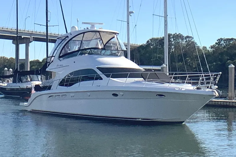 Slide: The Image of 2007 Sea Ray 52 Sedan Bridge yacht docked in a marina, under clear blue skies. - 10