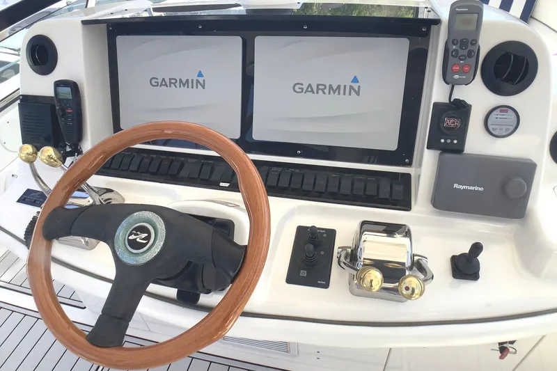 Slide: The Image of 2007 Sea Ray 52 Sedan Bridge helm with Garmin displays and wooden steering wheel. - 15