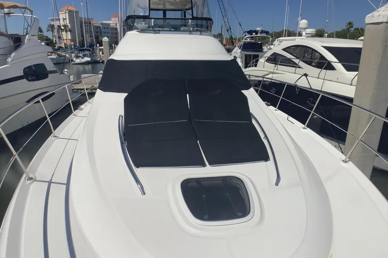 Slide: The Image of 2007 Sea Ray 52 Sedan Bridge yacht docked at marina, featuring sleek design and sunbathing area. - 24