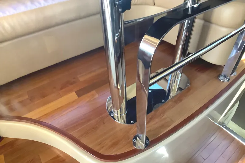 Slide: The Image of Interior of 2007 Sea Ray 52 Sedan Bridge with polished metal railings and wooden flooring. - 30