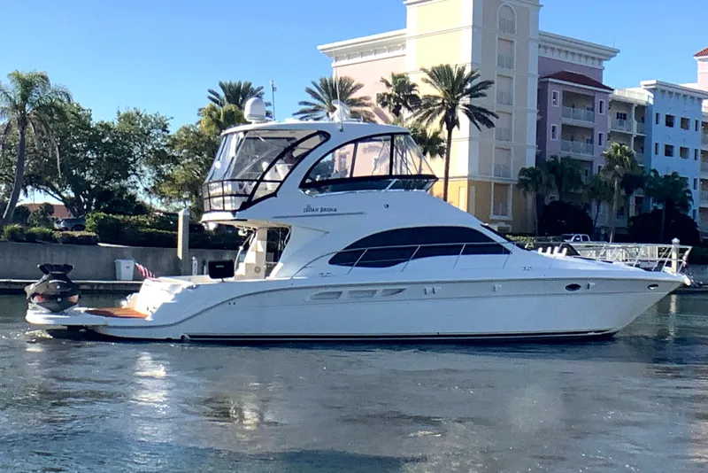 Slide: The Image of 2007 Sea Ray 52 Sedan Bridge yacht docked near waterfront buildings and palm trees. - 6