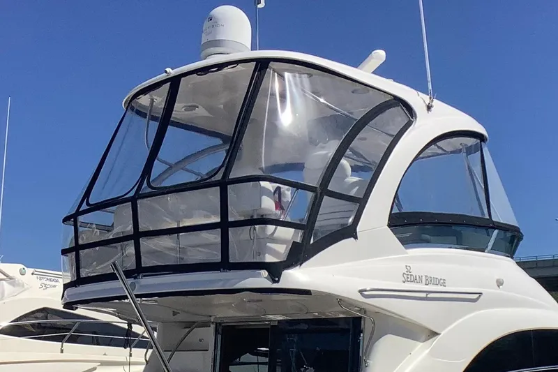 Slide: The Image of 2007 Sea Ray 52 Sedan Bridge yacht with enclosed flybridge, docked under clear blue sky. - 8
