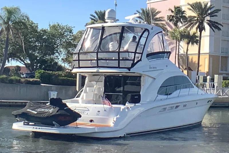 Slide: The Image of 2007 Sea Ray 52 Sedan Bridge yacht docked, featuring sleek design and spacious upper deck. - 9