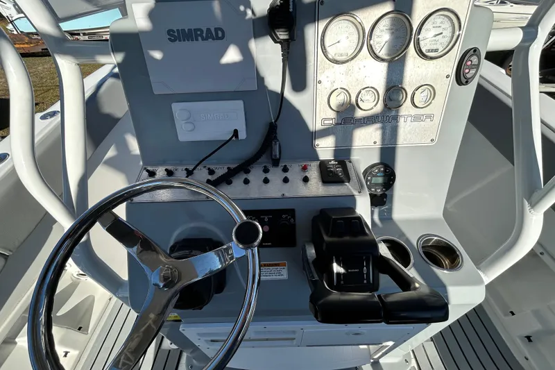 Slide: The Image of 2022 Clearwater 2300 boat dashboard with steering wheel, gauges, and controls. - 13