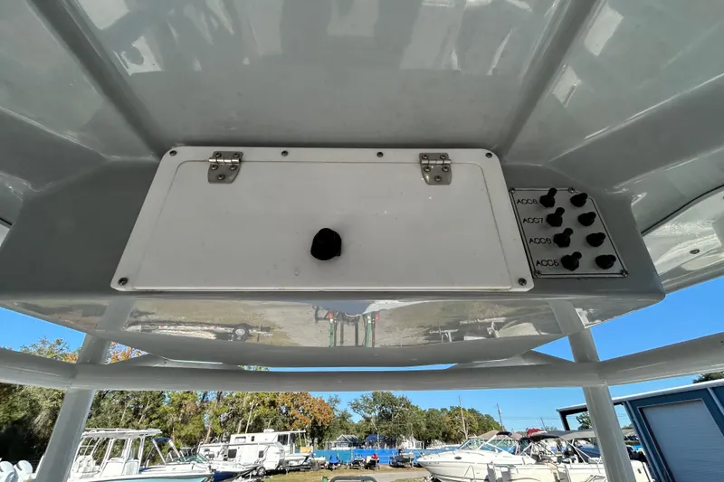 Slide: The Image of Control panel on a 2022 Clearwater 2300 boat, featuring switches and storage compartment. - 16