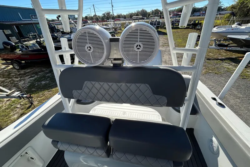 Slide: The Image of 2022 Clearwater 2300 boat interior with dual speakers and cushioned seating. - 17