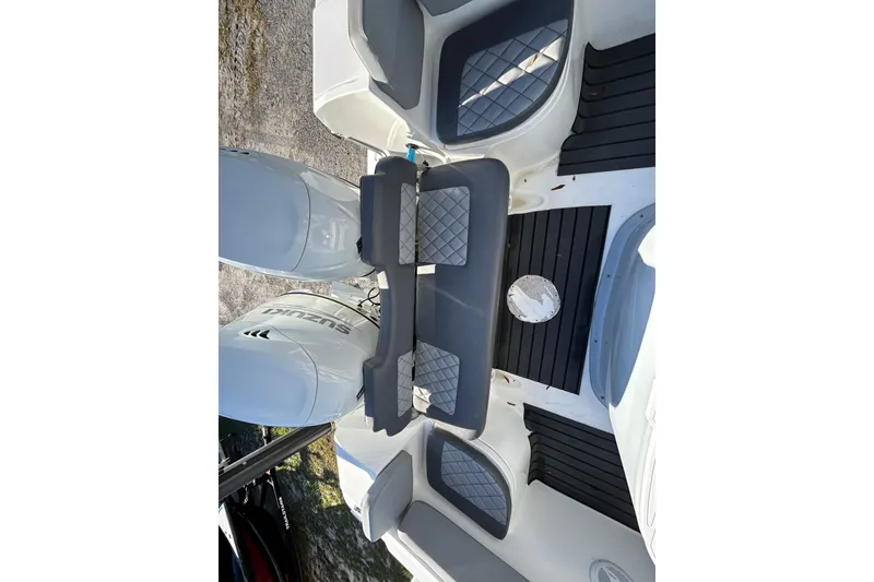 Slide: The Image of 2022 Clearwater 2300 boat interior with dual Suzuki engines and cushioned seating. - 20