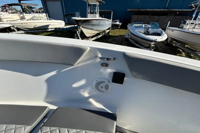Slide: The Image of 2022 Clearwater 2300 boat interior with seating and speaker, surrounded by other boats. - 6