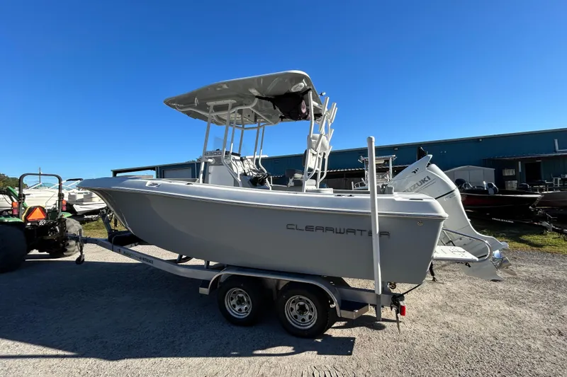 The Image of 2022 Clearwater 2300 boat on trailer, parked outdoors under clear blue sky. - 1