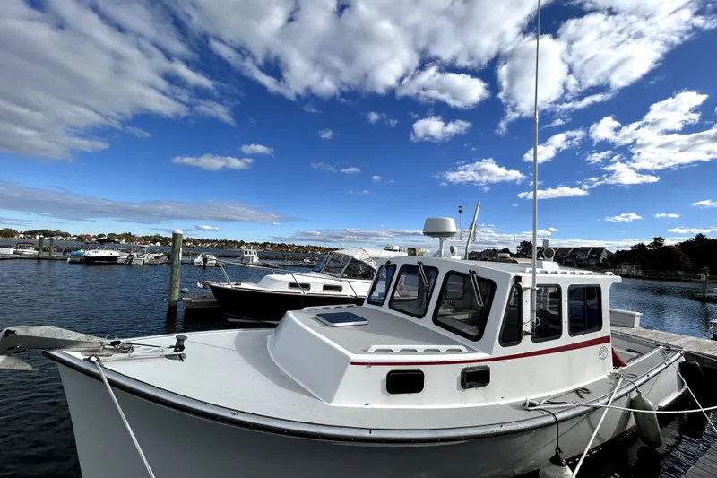 Slide: The Image of 1988 Duffy 31 Lobster Boat docked under a bright blue sky. - 10