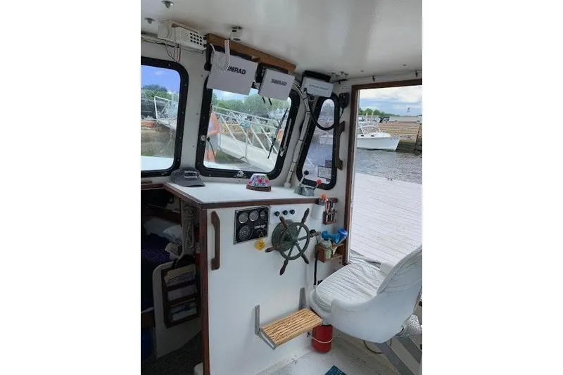 Slide: The Image of Interior of a 1988 Duffy 31 Lobster Boat with steering wheel and navigation equipment. - 16