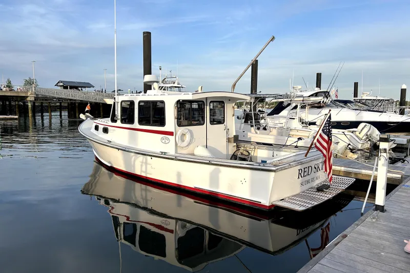 Slide: The Image of 1988 Duffy 31 Lobster Boat docked, displaying American flag, calm water reflection. - 4