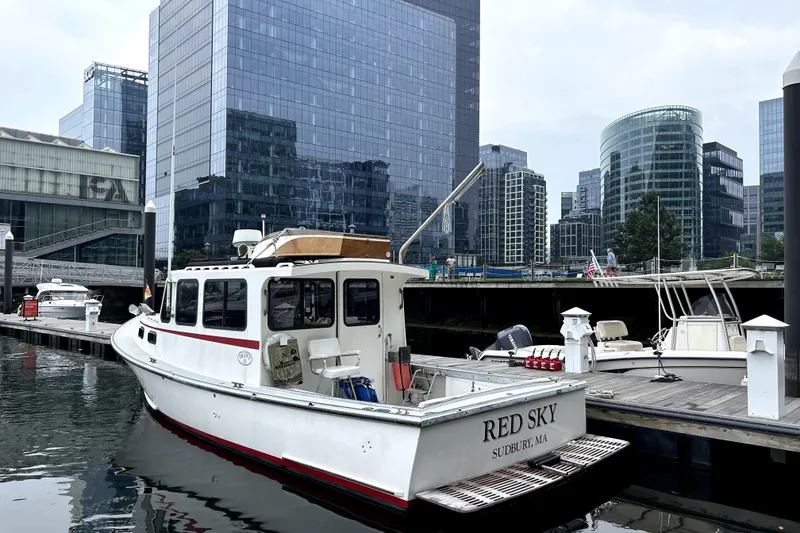 Slide: The Image of 1988 Duffy 31 Lobster Boat docked in urban marina with modern skyscrapers. - 6