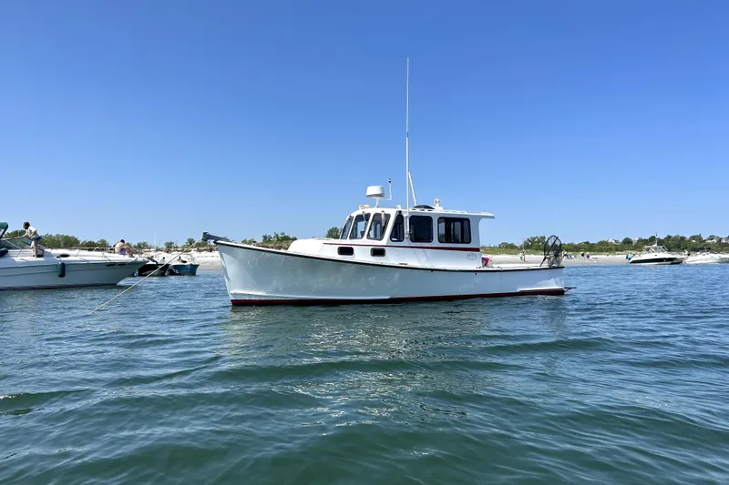 Slide: The Image of 1988 Duffy 31 Lobster Boat on calm water under clear blue sky. - 9