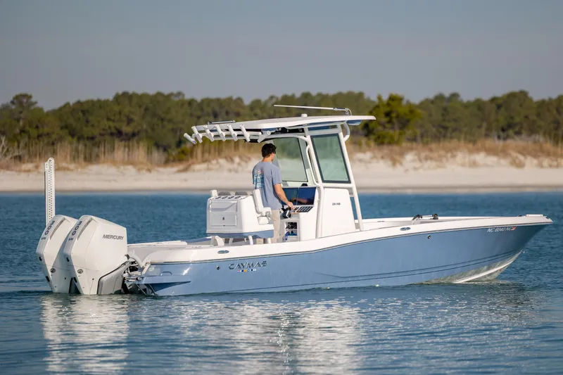 The Image of 2024 Caymas 281 HB boat cruising on calm water near a sandy shoreline. - 0