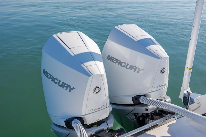 Slide: The Image of Twin Mercury outboard engines on a 2024 Caymas 281 HB boat in calm waters. - 10