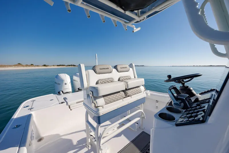 Slide: The Image of 2024 Caymas 281 HB boat interior with dual seats and control panel on calm water. - 16