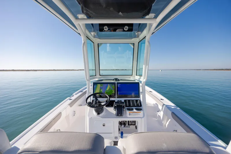 Slide: The Image of 2024 Caymas 281 HB boat helm with navigation screens on calm water. - 18