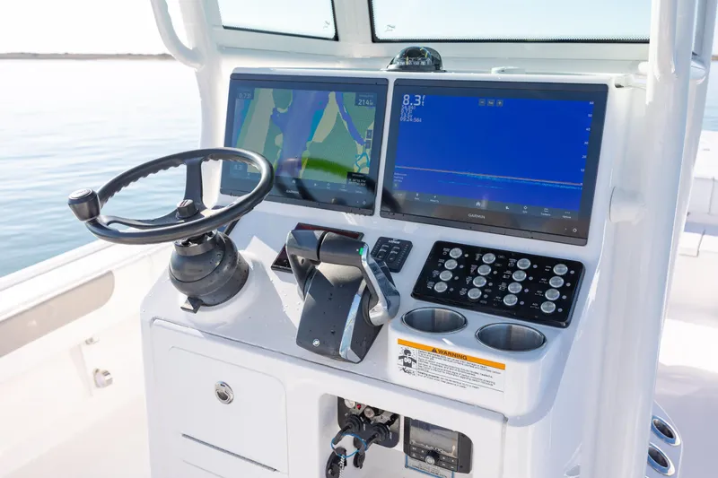 Slide: The Image of 2024 Caymas 281 HB boat dashboard with dual navigation screens and steering wheel. - 19