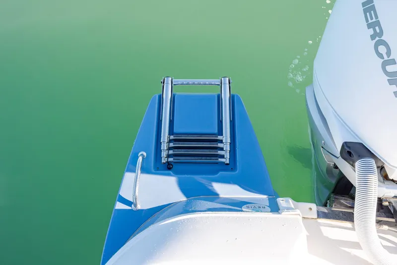 Slide: The Image of 2024 Caymas 281 HB boat with a folded swim ladder and Mercury engine. - 24