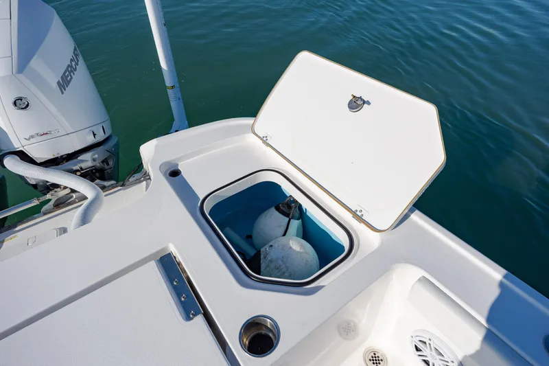 Slide: The Image of 2024 Caymas 281 HB boat with open storage compartment and Mercury engine on water. - 28