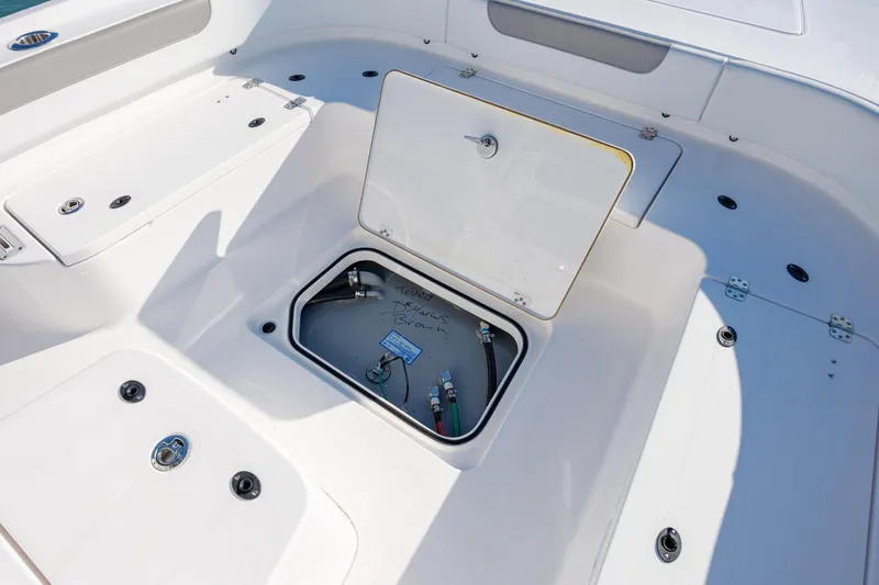 Slide: The Image of 2024 Caymas 281 HB boat storage compartment with open hatch and visible wiring. - 31