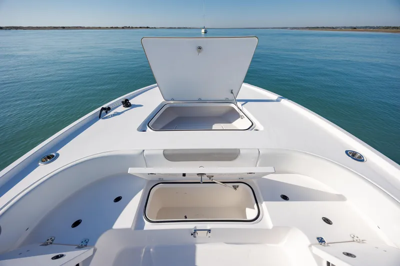 Slide: The Image of 2024 Caymas 281 HB boat deck with open storage compartments on calm water. - 34