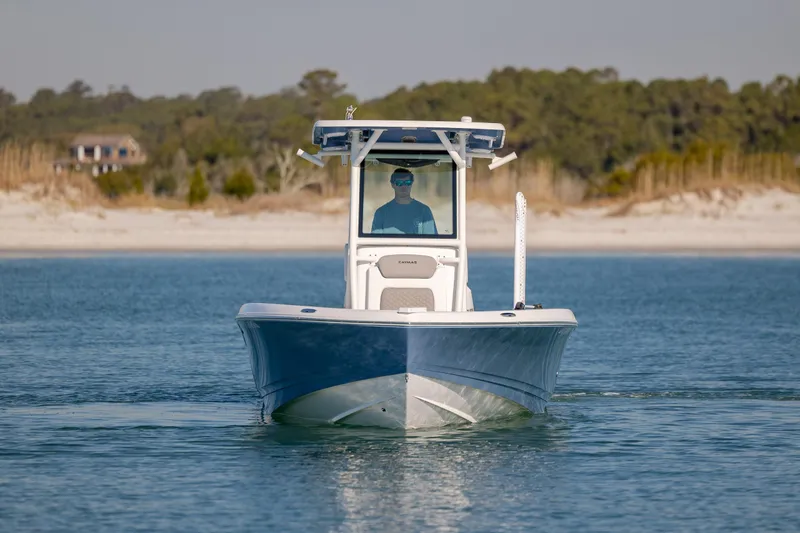 Slide: The Image of 2024 Caymas 281 HB boat cruising on calm water near a sandy shoreline. - 4