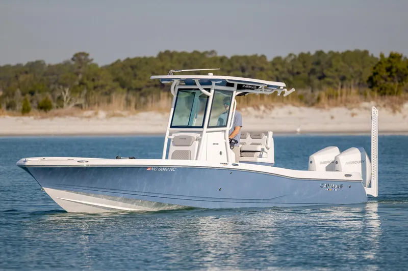 Slide: The Image of 2024 Caymas 281 HB boat cruising on calm water near a sandy shoreline. - 6