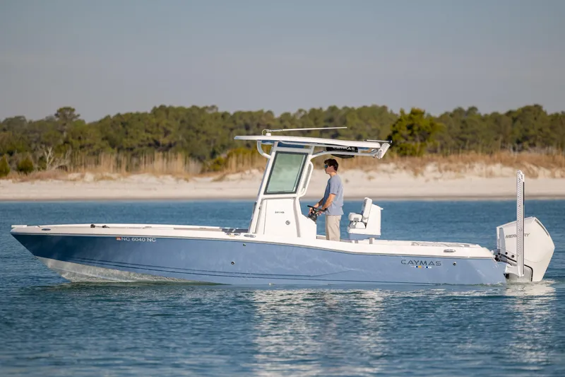 Slide: The Image of 2024 Caymas 281 HB boat cruising on calm water near a sandy shoreline. - 7