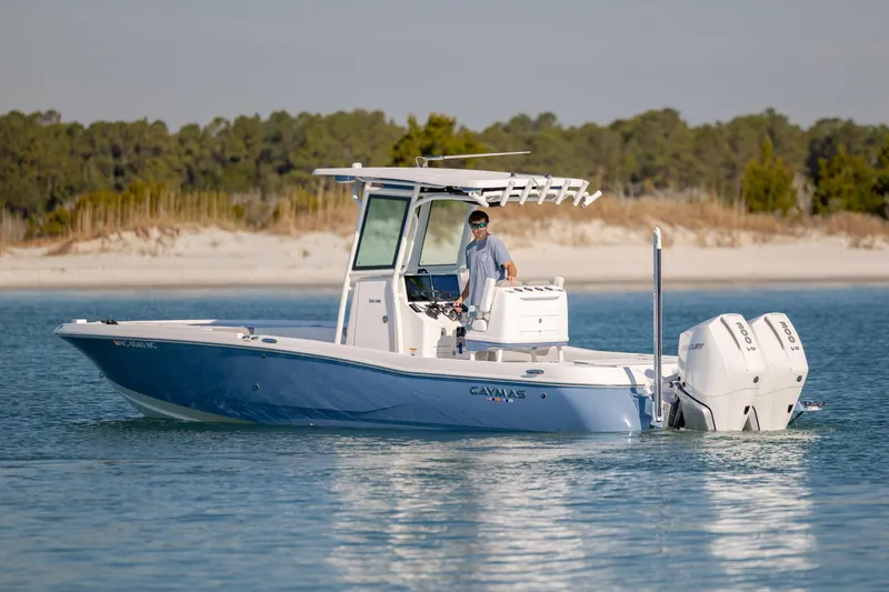 Slide: The Image of 2024 Caymas 281 HB boat cruising on calm water near a sandy shoreline. - 8